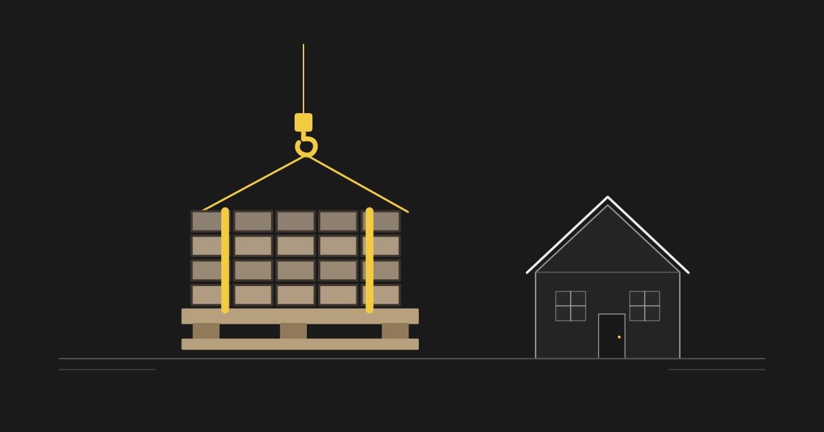 Een pallet dakpannen met hijsbanden naast een woning.